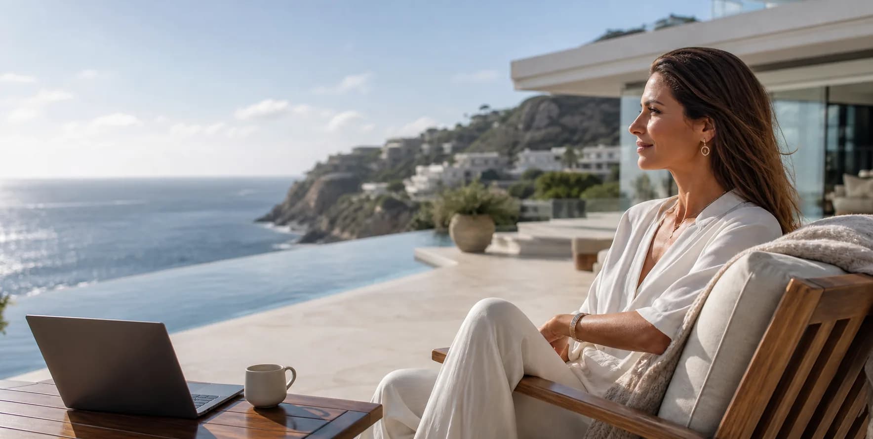 Eine Frau genießt einen ruhigen luxuriösen Arbeitstag an einem Infinity-Pool mit Meerblick